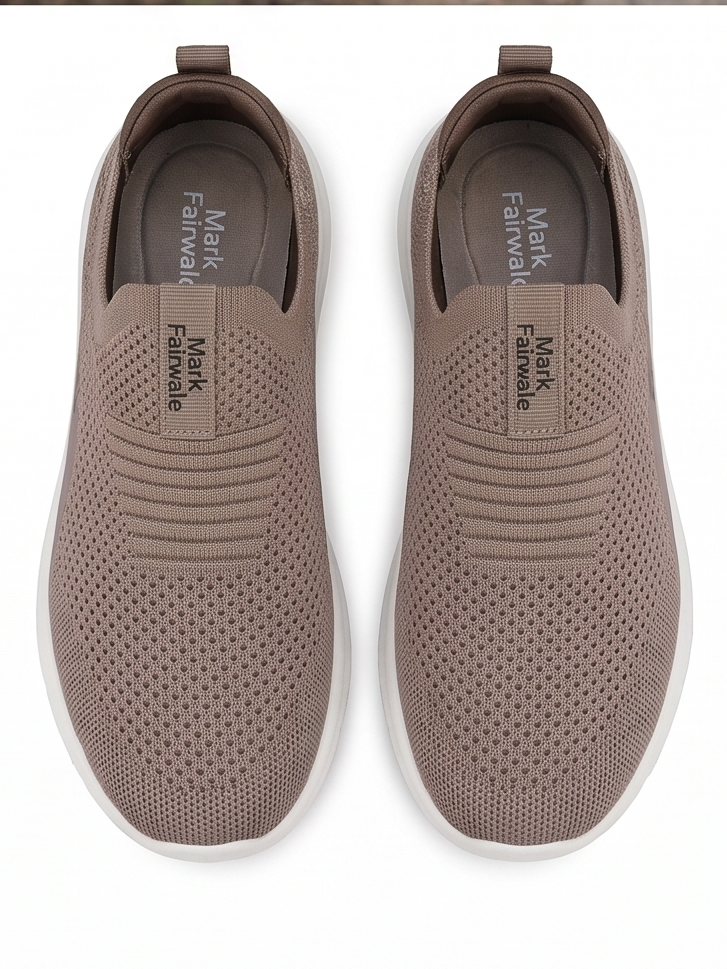 Pair of brown slip-on shoes with white soles on a white background